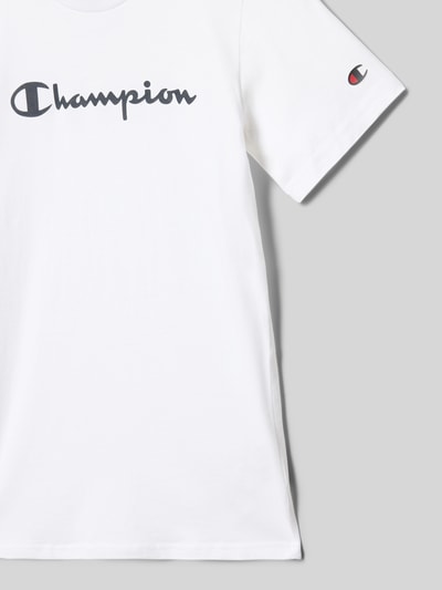 Produktfoto, T-Shirt aus reiner Baumwolle von Champion, weiße Farbe, Label-Print, gerade Passform, Rundhalsausschnitt, Rückenlänge bei Größe 140: 54 cm.