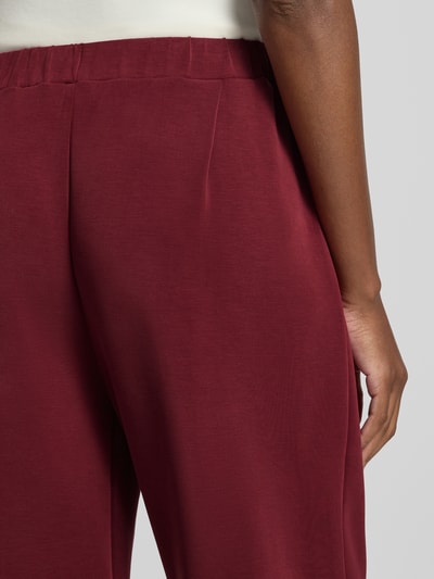 Frauenmodel trägt Regular Fit Sweathose aus Modal-Mix Modell 'TENNY' von Selected in dunklem Rot, glatte Textur, Detailaufnahme, Damen Sweathose von Selected.