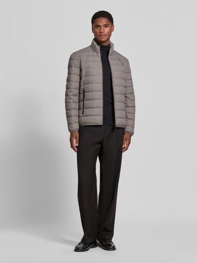 Männermodel trägt Regular Fit Steppjacke mit Zweiwege-Reißverschluss von Marc O'Polo in Grau, glatte Oberfläche, Ganzkörperansicht von vorne. Herren Steppjacke von Marc O'Polo
