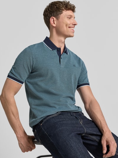 Männermodel trägt Regular Fit Poloshirt mit Label-Stitching von bugatti, reine Baumwolle, Knopfleiste, Blau, Nahaufnahme Oberkörper.