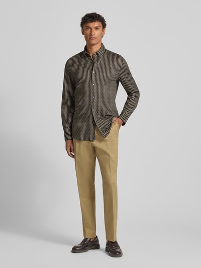 Männermodel trägt Freizeithemd mit Knopfleiste von Emporio Armani, Lyocell-Baumwoll-Mix, Regular-Fit, Kentkragen, Hosen in Beige, Ganzkörperansicht von vorne.