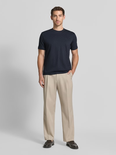 Männermodel trägt T-Shirt mit Logo-Stitching Modell 'Benluco' von JOOP!, Baumwolle, Strukturmuster, Regular Fit, Ganzkörperansicht von vorne.