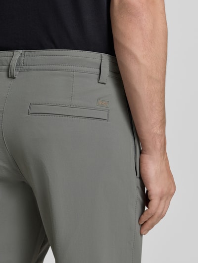 Männermodel trägt Straight-Tapered Fit Chino mit Bund Tunnelzug Modell 'CHINO' von BOSS Orange, unifarben, label patch, detailaufnahme.