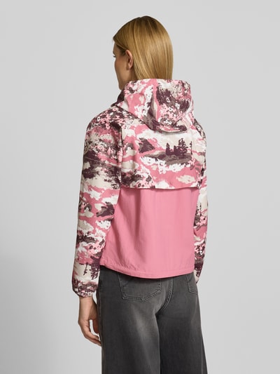 Frauenmodel trägt Regular Fit Jacke mit Kapuze Modell 'Spired Valley' von COLUMBIA, rosa-graues Camouflage-Muster, AufgesetzteTaschen, Rückenlänge 59 cm, Schulterbreite 42 cm, Brustweite 55 cm, Ärmellänge 60 cm, Ganzkörperansicht Rückansicht.