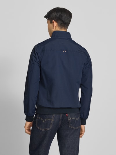 Männermodel trägt Jacke mit Stehkragen und Eingrifftaschen von Superdry in Dunkelblau, Regular-Fit, Rückenansicht, Rückenlänge 70 cm, Schulterbreite 44 cm, Brustweite 41 cm, Ärmellänge 68 cm.