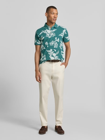 Männermodel trägt Modern Fit Poloshirt mit Label-Detail von Lerros, grün mit weißem Blumenmuster, Baumwolle, Ganzkörperansicht von vorne.