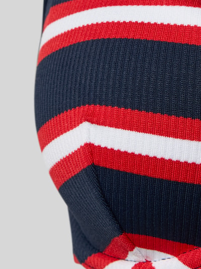Nahaufnahme Oberkörper, Frauenmodel trägt Bikini-Oberteil aus geripptem Material von TOMMY HILFIGER, mehrfarbig mit Streifenoptik.