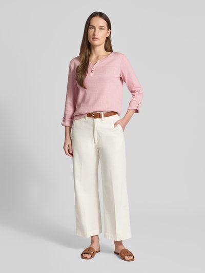 Modelka nosi Regular Fit Langarmshirt aus Baumwoll-Mix von Tom Tailor, gładki, różowy, dwukolorowy, V-neck, długi rękaw, dzianina prążkowana; widok całej sylwetki z przodu.