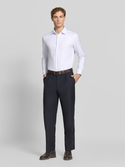 Männermodel trägt Slim Fit Businesshemd aus reiner Baumwolle von Seidensticker in Weiß mit feiner Struktur, dunkle Hose, Ganzkörperansicht von vorne, Herren Businesshemd von Seidensticker.