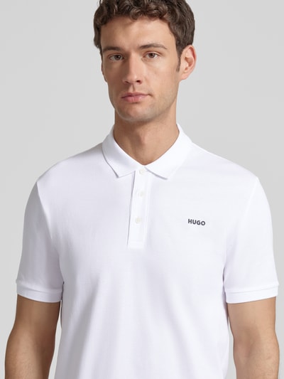 Männermodel trägt Regular Fit Poloshirt aus reiner Baumwolle Modell 'DONOS222' von HUGO, Optik: Unifarben, Nahaufnahme Oberkörper.