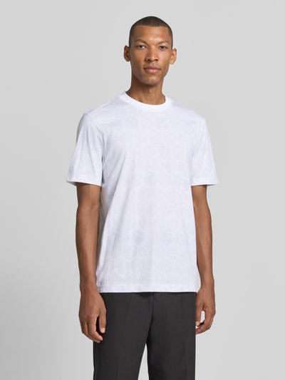 Männermodel trägt Regular Fit T-Shirt aus reiner Baumwolle von BOSS für BOSS Green in Weiß mit dezent gemusterten Flächen, Ganzkörperansicht von vorne.