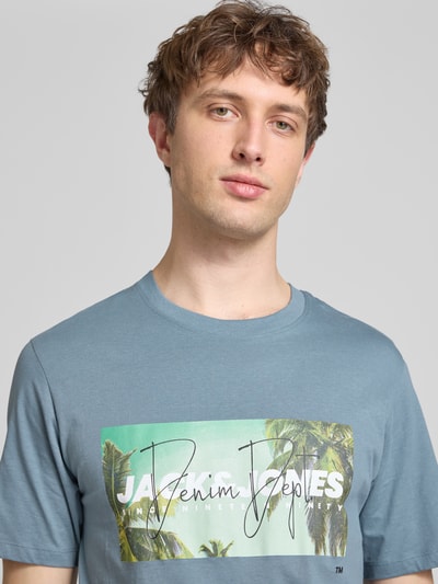 Männermodel trägt Herren T-Shirt mit Label-Print Modell 'INDIANA' von Jack & Jones in Blau aus reiner Baumwolle, Regular-Fit, Nahaufnahme Oberkörper.
