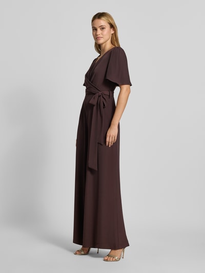 Frauenmodel trägt Jumpsuit mit Stoffgürtel von Rinascimento in Braun, V-Ausschnitt, Kurzarm, Material-Mix, Ganzkörperansicht von vorne.