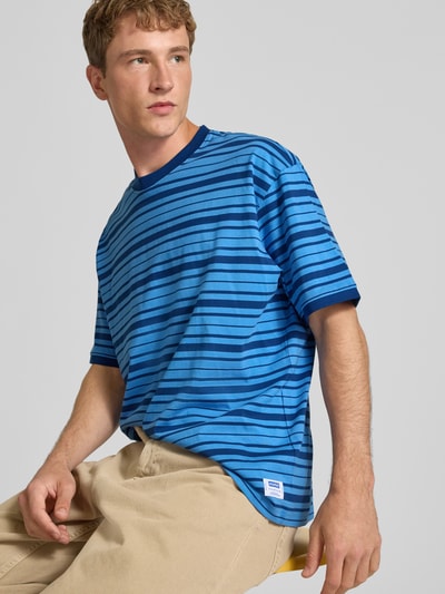 Männermodel trägt Regular Fit T-Shirt aus reiner Baumwolle Modell 'Nistripe' von HUGO in Blau mit Streifen, Herren T-Shirt von HUGO Blue, Nahaufnahme Oberkörper.