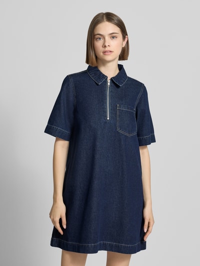 Frauenmodel trägt Jeanskleid mit Reißverschluss Modell 'AMARA KLARA' von JJXX aus Baumwoll-Viskose-Mix in Dunkelblau, A-Linie, Minikleid, Hemdblusenkragen, Brusttasche, Nahaufnahme Oberkörper, Rückenlänge 85 cm, Brustweite 47 cm, Ärmellänge 28 cm.