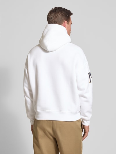 Mannelijk model draagt Relaxed Fit Hoodie uit katoenmix van Polo Ralph Lauren in effen wit met labelstitching, kangoeroezak, capuchon met tunnelkoord, lange mouwen met geribde mouwboord en geribde rompzoom, sweatmateriaal, Ganzkörperansicht Rückansicht.