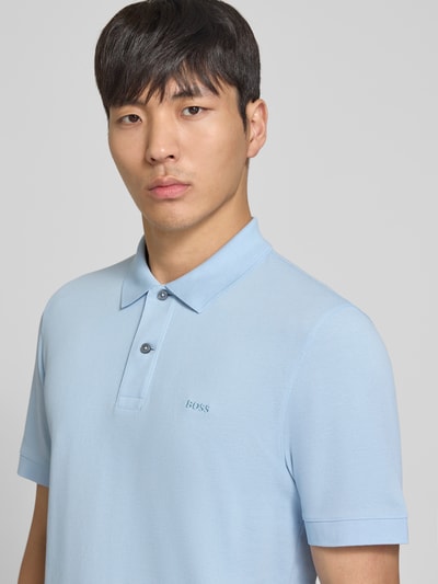 Männermodel trägt Regular Fit Poloshirt aus reiner Baumwolle Modell 'PALLAS' von BOSS in Optik: Unifarben, Nahaufnahme Oberkörper.