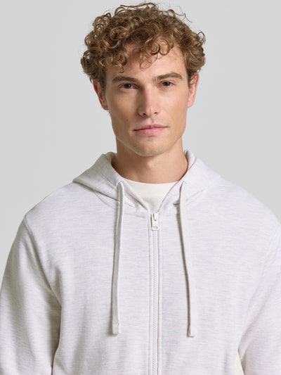 Męski model nosi Relaxed Fit Sweatjacke aus reiner Baumwolle von s.Oliver RED LABEL, jasna bluza rozpinana, tekstura bawełny, Nahaufnahme Oberkörper.