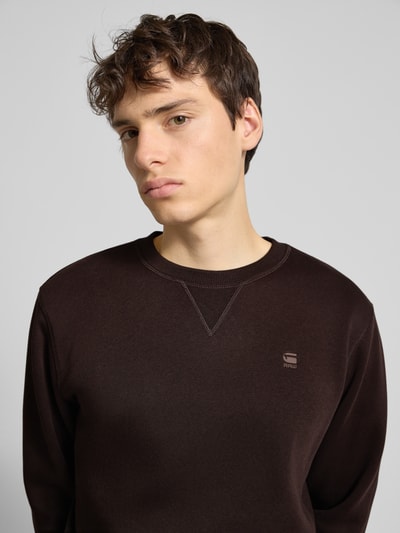 Männermodel draagt Sweatshirt aus Baumwoll-Mix Modell 'Premium core' van G-star, recht pasvorm, ronde hals, labelstitching, elastische boorden, katoenmix, kleur bruin, Nahaufnahme Oberkörper.