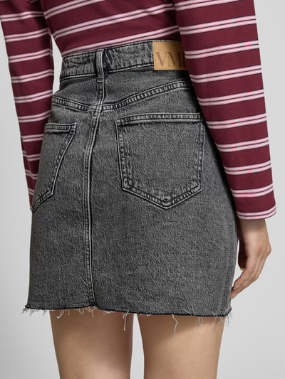 Frauenmodel trägt Regular Fit Jeansrock aus Baumwoll-Mix Modell 'TESSA' von Vero Moda, grauer Denim, 5-Pocket, Label Patch, Ganzkörperansicht Rückansicht