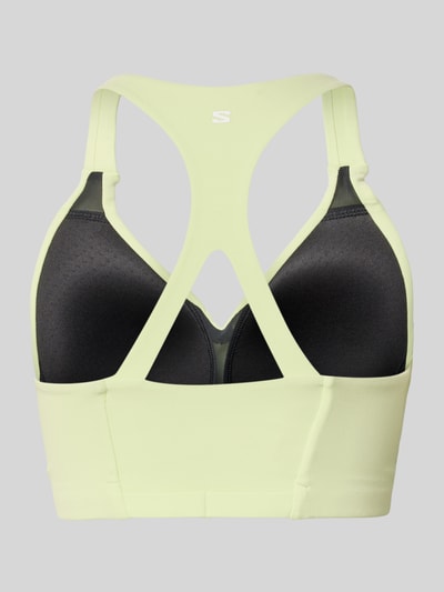 Vrouwenmodel draagt Racerback-Bustier met Logo van Salomon, lichte kleur, aansluitende pasvorm, stretchmateriaal, logo, racerback. Ganzkörperansicht Rückansicht.