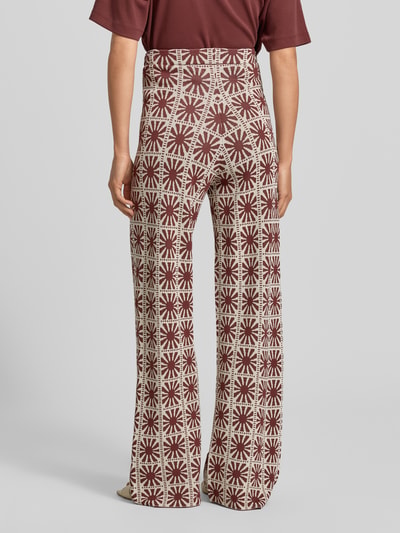 Frauenmodel trägt Flared Cut Hose im Allover-Look Modell 'JASPER' von SUNCOO PARIS aus Viskose-Mix mit Elastischer Bund, Ganzkörperansicht Rückansicht.