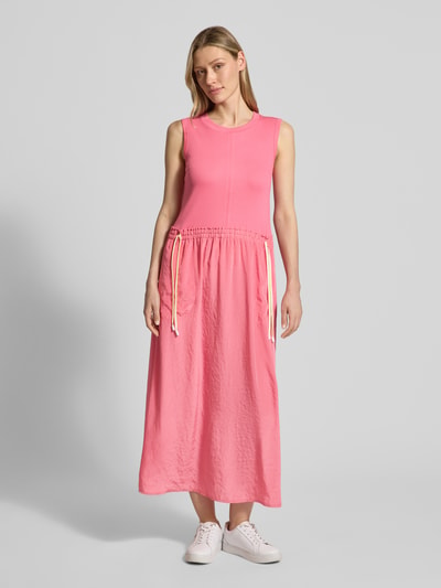 Modelka nosi długa sukienka 'Maxikleid mit Kordelzug an der Taille' od Marc Cain, mieszanka bawełny z dodatkiem streczu, taliowany fason, okrągły dekolt, troki w talii, długość tyłu w rozmiarze 36: 124 cm, szerokość w rozmiarze 36: 42 cm, całość w odcieniach różu, gładka faktura, pełny widok z przodu.