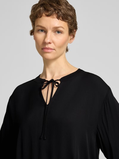Frauenmodel trägt Bluse aus Viskose mit Schlüsselloch-Ausschnitt von Emily Van den Bergh, schwarz, Loose Fit, Nahaufnahme Oberkörper.