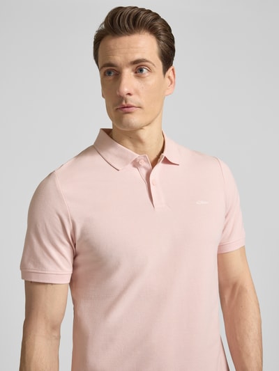 Männermodel trägt Regular Fit Poloshirt aus reiner Baumwolle von s.Oliver RED LABEL in Rosa, unifarben, Nahaufnahme Oberkörper.