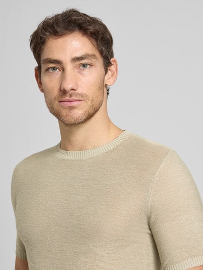 Męski model nosi Slim Fit T-Shirt aus Leinen-Mix in Strick-Optik od Antony Morato, jasnobeżowy, okrągły dekolt, krótki rękaw, miks lnu i wiskozy, elastyczne wykończenia; krój slim fit, długość tyłu w rozmiarze M: 72 cm, zbliżenie górnej części ciała z przodu.