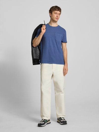 Männermodel trägt T-Shirt aus Baumwoll-Leinen-Mix mit Brusttasche von Superdry in Blau, Regular-Fit, Rundhalsausschnitt, Herren T-Shirt, Rückenlänge 66 cm bei Größe M, Ganzkörperansicht von vorne.