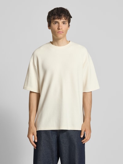 Männermodel trägt T-Shirt mit Strukturmuster und Rundhalsausschnitt Modell 'PETER' von Redefined Rebel in Beige, Relaxed Fit, Ganzkörperansicht von vorne. Baumwoll-Mix, Rückenlänge bei Größe M: 70 cm.