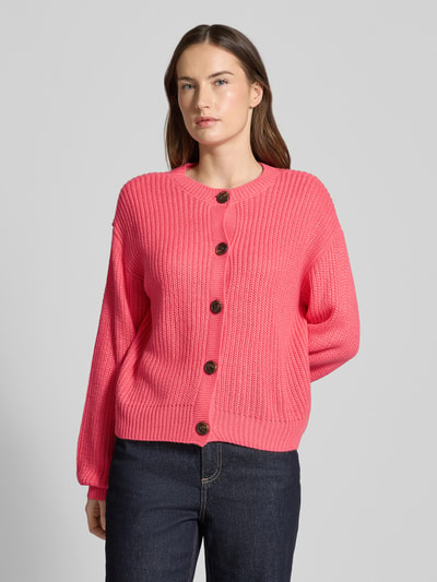 Vrouwenmodel draagt Regular Fit Strickjacke met eenrijige knoopsluiting model 'LEA' van Vero Moda, effen roze, ronde hals, ribdetails, langemouw, gebreide textuur. Vooraanzicht, bovenlichaam close-up.