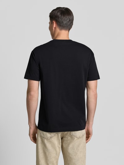 Männermodel trägt Relaxed Fit T-Shirt aus reiner Baumwolle von Marc O'Polo in Unifarben, Jersey-Textur, Rundhals, Ganzkörperansicht Rückansicht.
