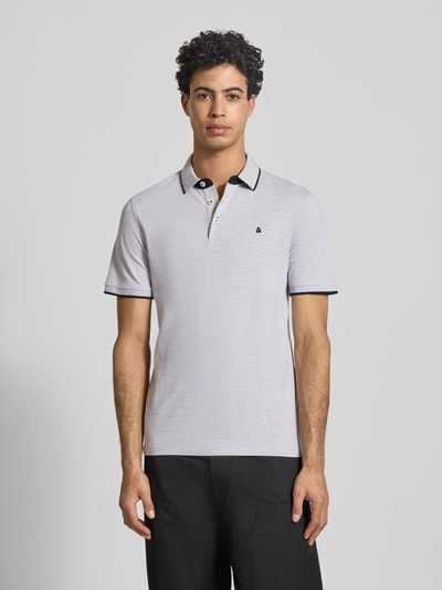 Männermodel trägt Slim Fit Poloshirt mit Viskose-Anteil Modell 'Paulos' von JACK & JONES, Baumwoll-Mix, Polokragen, Kurzärmelig, Logo-Stitching, Rückenlänge bei Größe M 72 cm, Ganzkörperansicht von vorne