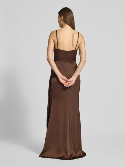 Frauenmodel trägt Abendkleid aus Satin in Wickel-Optik von Mascara in Braun mit Spaghettiträgern und Maxilänge, Ganzkörperansicht Rückansicht. Eng anliegende Passform, tiefer V-Ausschnitt, rückseitiger Nahtreißverschluss, gelegte Falten, tiefer Gehschlitz, Rückenlänge bei Größe 36: 156 cm, Brustweite bei Größe 36: 38 cm.