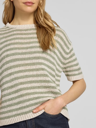 Frauenmodel trägt Loose Fit Pullover aus Baumwoll-Mix von Marc O'Polo, Optik:Allover-Muster, Passform:Loose-Fit, gestreift, Materialverarbeitung:Strick, Rundhals, Kurzarm, Ärmelabschluss:Gerippt, Rumpfabschluss:Gerippt, Material:Baumwoll-Mix, grün-weiß gestreift, Nahaufnahme Oberkörper.