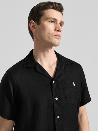 Männermodel trägt Regular Fit Freizeithemd aus reinem Leinen von Polo Ralph Lauren in Schwarz mit Reverskragen, Brusttasche, Logo-Stitching, Nahaufnahme Oberkörper.
