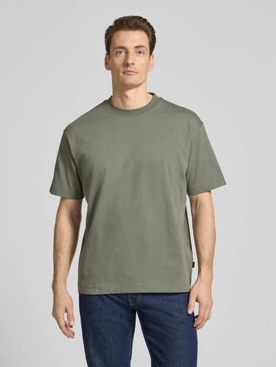 Männermodel trägt Regular Fit T-Shirt aus reiner Baumwolle Modell 'TEETIMM' von BOSS Orange in Unifarben, Rundhals, kurzarm, Ganzkörperansicht von vorne.