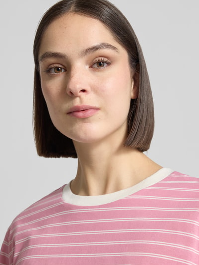 Kobiece modelka nosi Boxy Fit T-Shirt aus reiner Baumwolle von Tom Tailor Denim, różowe w białe paski, logo-patch, okrągły dekolt, krótki rękaw, drobny prążkowany materiał, czysta bawełna, kolorowa, zbliżenie na górną część ciała