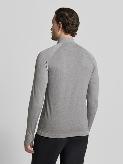 Männermodel trägt graues Langarmshirt mit Troyer Modell 'THE TRAINING DAY QUARTER' von Fabletics, Material-Mix, Regular-Fit, Raglanärmel, Label-Detail, Rückenlänge bei Größe M 71 cm, Ganzkörperansicht Rückansicht.