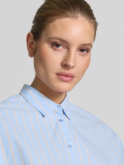 Kobiece model prezentuje Relaxed Fit Damenbluse mit Streifenmuster od Emily Van den Bergh, bawełna, niebieskie i beżowe paski, kołnierzyk koszulowy, zapięcie na guziki, długość tyłu 65 cm, długość rękawa 41 cm, widok z przodu, zbliżenie na górną część ciała.