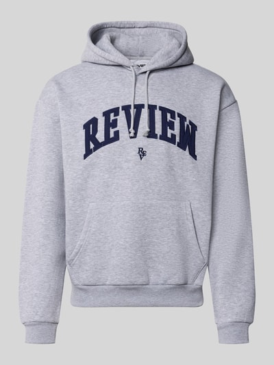 Produktfoto, Hoodie mit Label-Stitching von REVIEW aus Baumwollmischung in Grau mit dunkelblauem Schriftzug, lockere Passform, Känguru-Tasche