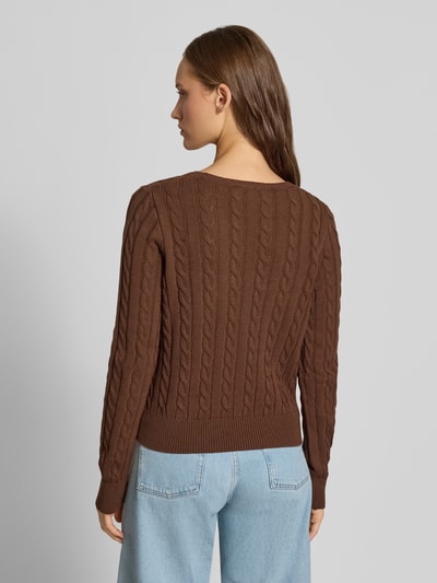 Vrouwenmodel draagt Slim Fit Pullover uit katoenmix van REVIEW in tricotlook met ronde hals, ruglengte maat S 53 cm, mouwlengte 68 cm, gebreid bruin, kabelpatroon, gebreide textuur, lichtblauwe jeans, volledige lichaamsweergave achterkant.