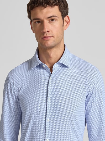 Męski model nosi Slim Fit Businesshemd mit Kentkragen Modell 'KENNO' od HUGO w niebieskim, jednolitym kolorze z drobnym wzorem, zbliżenie na górę ciała.