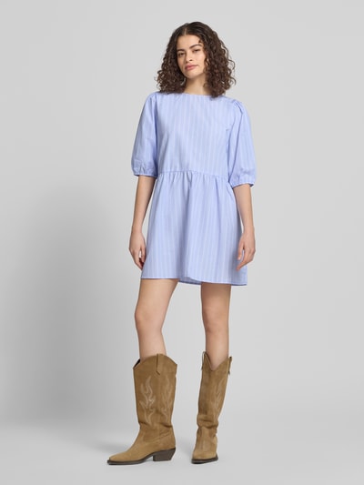 Frauenmodel trägt Relaxed Fit Blusenkleid mit Streifenmuster Modell 'CLARA TESSA' von Only, Mini-Länge, Rundhals, kurze Ballonärmel, recyceltes Material mit Baumwolle, sanfte Blautöne, Allover-Streifen, Ganzkörperansicht von vorne