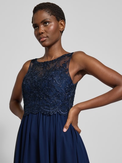 Frauenmodel trägt Abendkleid mit Ziersteinen und Floralen-Stickereien von LAONA in Dunkelblau, Taillierte Passform, Nahaufnahme Oberkörper.