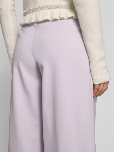 Vrouwenmodel draagt Wide Fit Stoffhose mit Bundfalten Modell 'Kate' van GUIDO MARIA KRETSCHMER WOMAN in lila, detailopname heup.