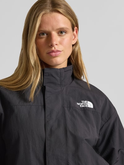 Frauenmodel trägt Jacke mit Wendefunktion Modell 'YUMIORI' von The North Face in Schwarz; Regular Fit, Stehkragen, Logo, Nahaufnahme Oberkörper. Rückenlänge, Schulterbreite, Brustweite und Ärmellänge bei Größe S gemäß Kontext.