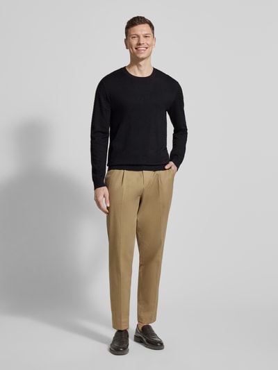 Männermodel trägt Strickpullover aus Viskose-Mix von ARMANI EXCHANGE in Schwarz mit Rundhalsausschnitt, Gerade Passform, Ganzkörperansicht von vorne.